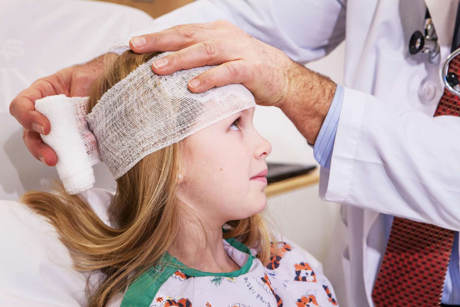 Médico envolvendo a cabeça da criança.