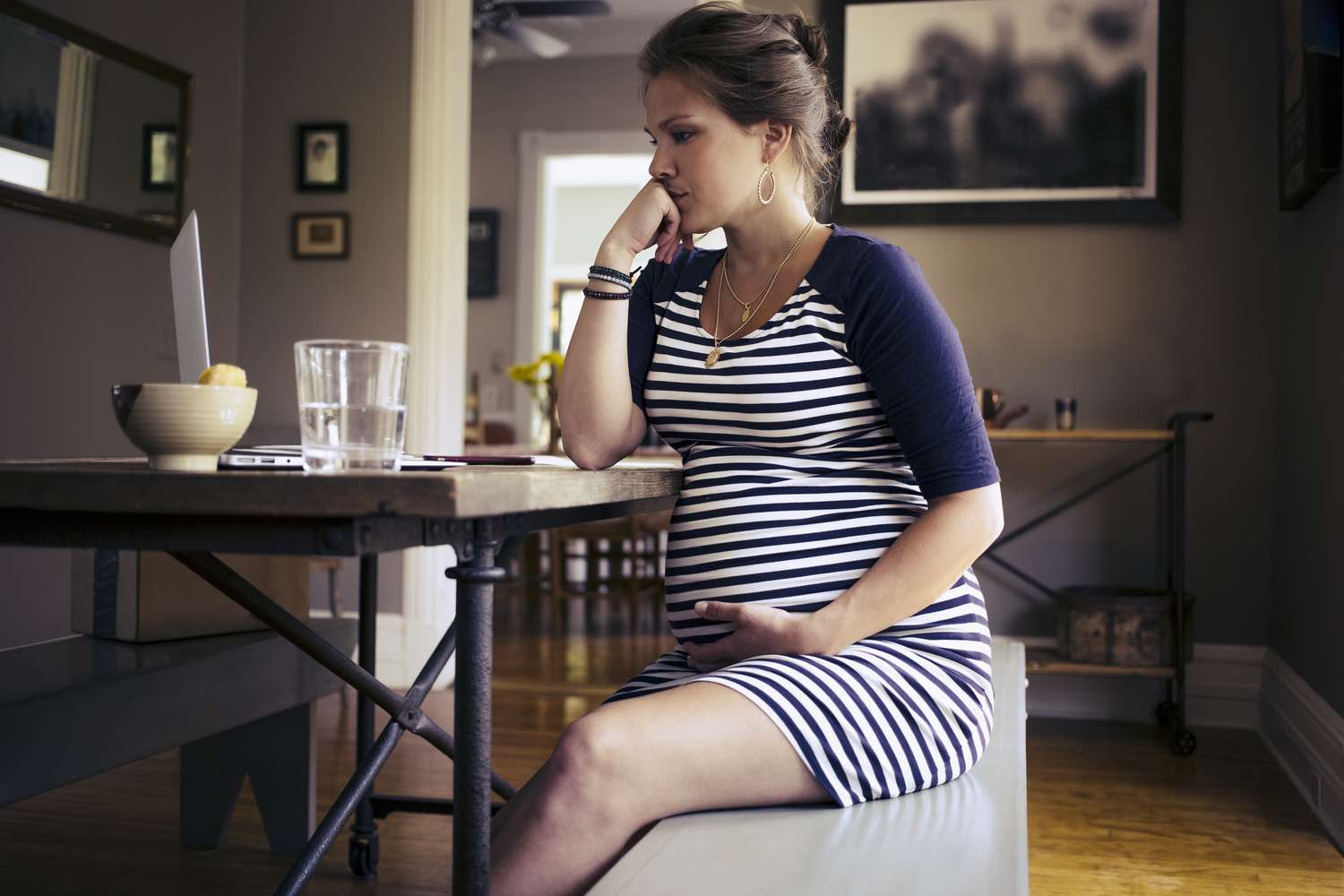 mulher grávida sentada em uma mesa