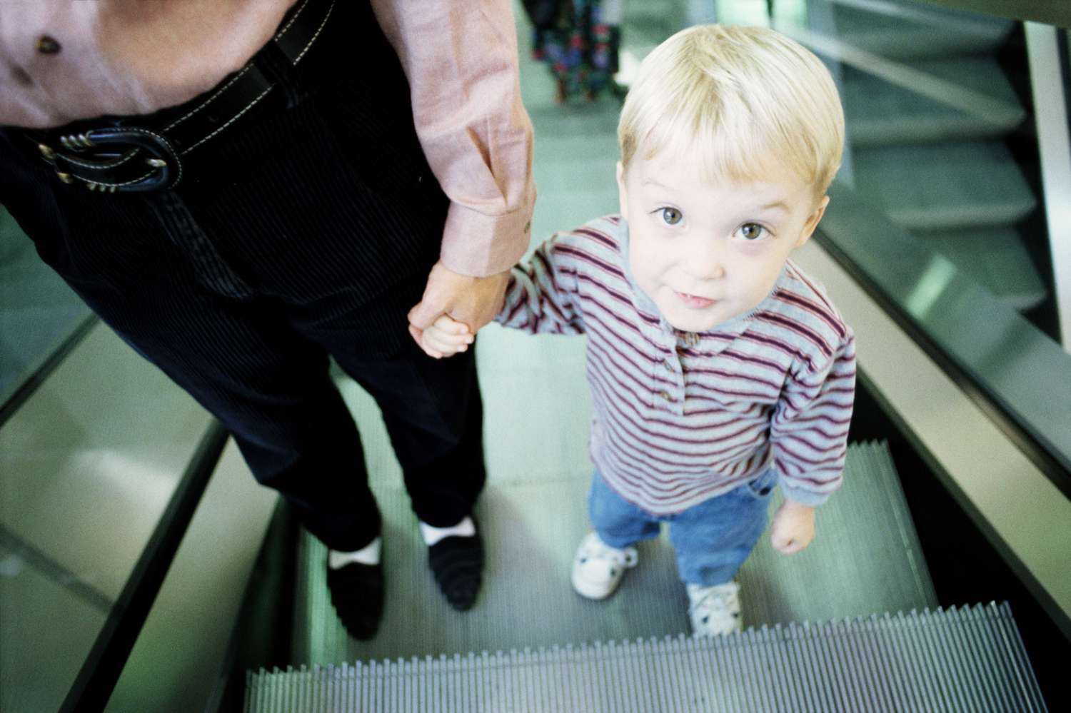 Menino com a mãe na escada rolante